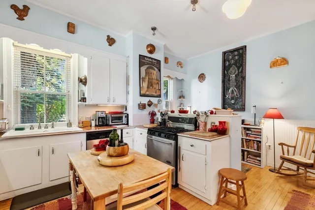 a kitchen with a stove a refrigerator and a dining table