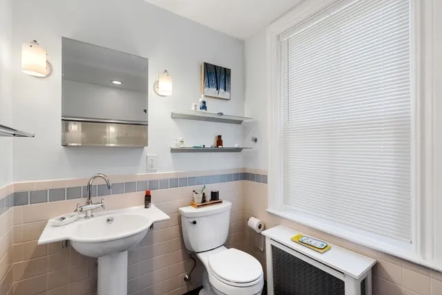 a bathroom with a sink a toilet and mirror