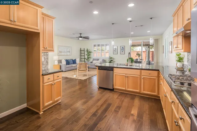 a kitchen with stainless steel appliances a stove top oven a sink a counter space and cabinets