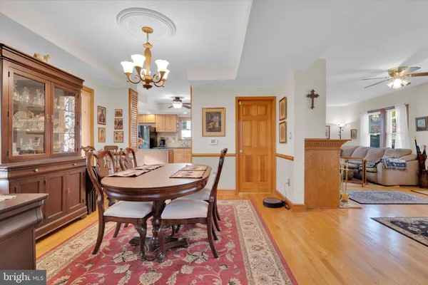 a view of a dining room with furniture a chandelier and wooden floor