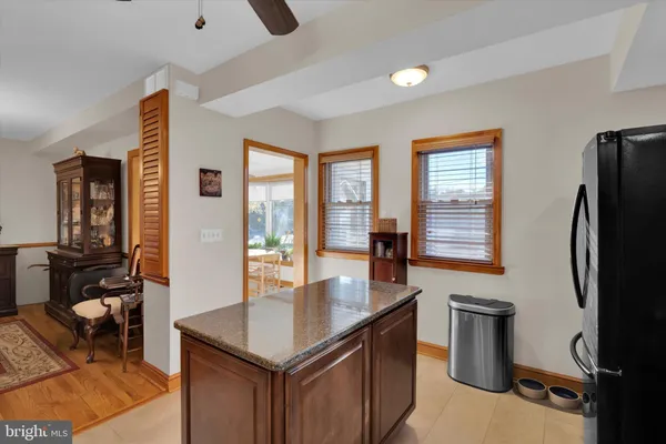 a kitchen with stainless steel appliances granite countertop a refrigerator a stove and a sink with living room