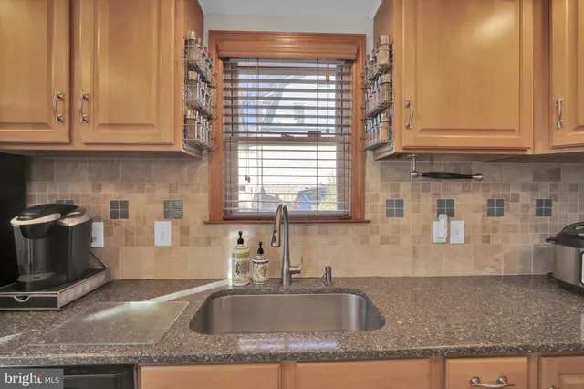 a kitchen with granite countertop a sink a stove and cabinets