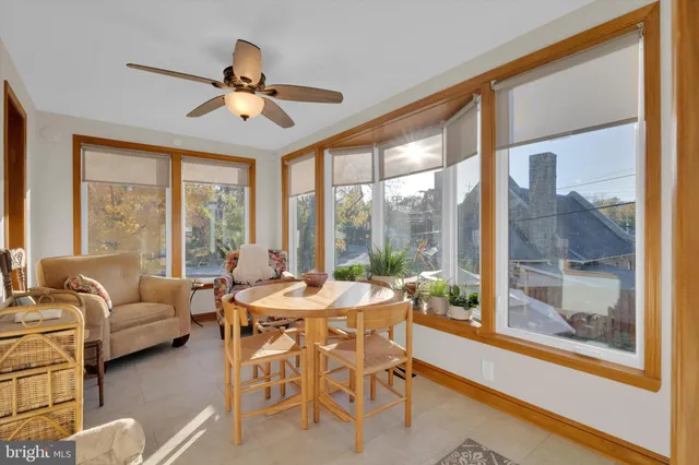a dining room with furniture a chandelier and a floor to ceiling window
