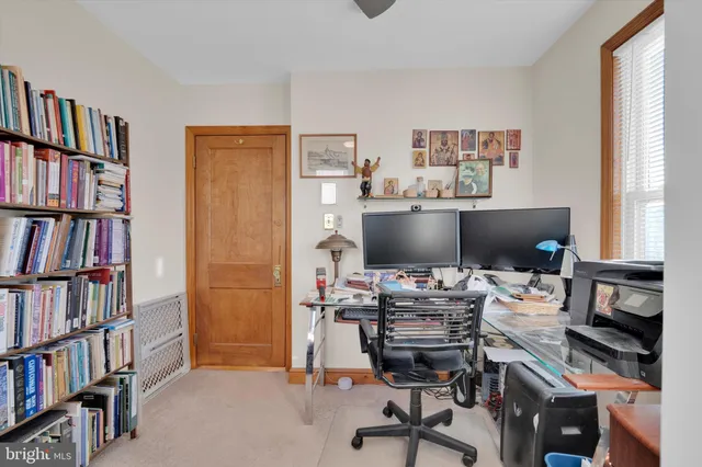 a view of a workspace with a bookshelf and a window
