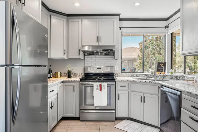 a kitchen with white cabinets and white appliances