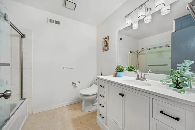 a bathroom with a granite countertop sink mirror and toilet