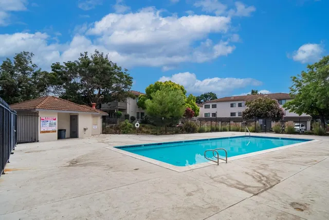 a view of a white house with a swimming pool and a yard