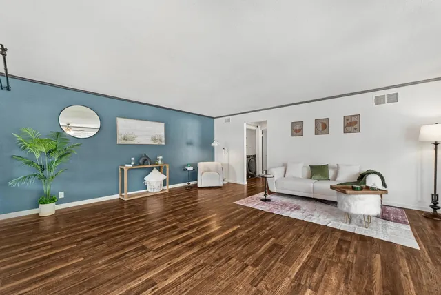 a living room with furniture and a wooden floor
