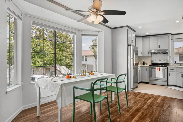 a kitchen with stainless steel appliances a table chairs and a refrigerator