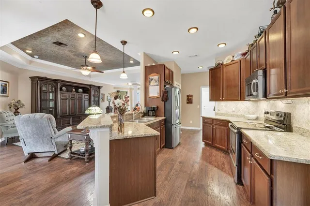 a large kitchen with stainless steel appliances kitchen island granite countertop a sink and cabinets