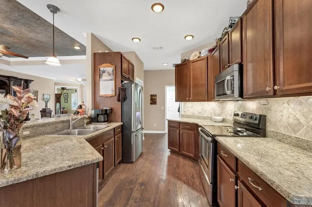 a kitchen with stainless steel appliances granite countertop a sink stove and refrigerator