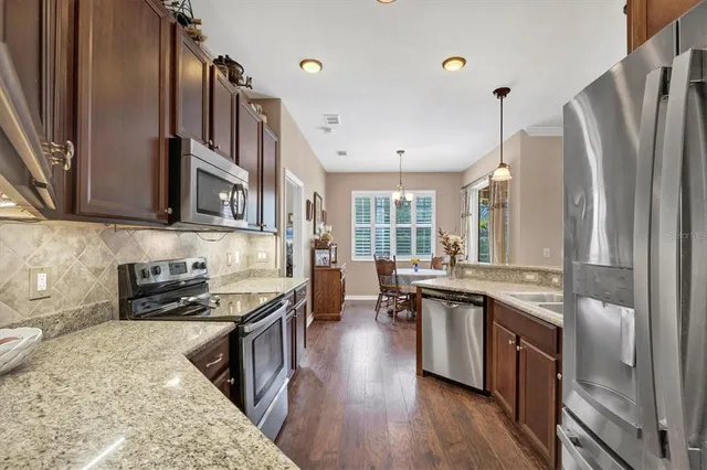 a kitchen with stainless steel appliances granite countertop a stove a sink dishwasher and a refrigerator