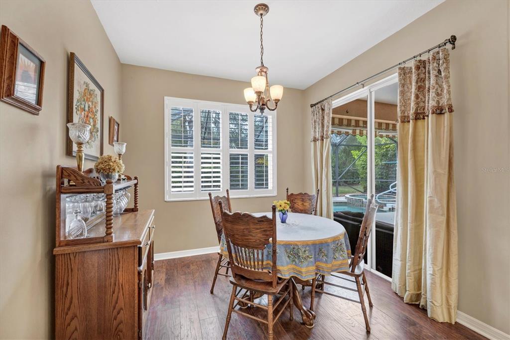 19792 Cobblestone Circle Venice, FL 34292 - Photo 15 of 36 a dining room with furniture large windows and wooden floor