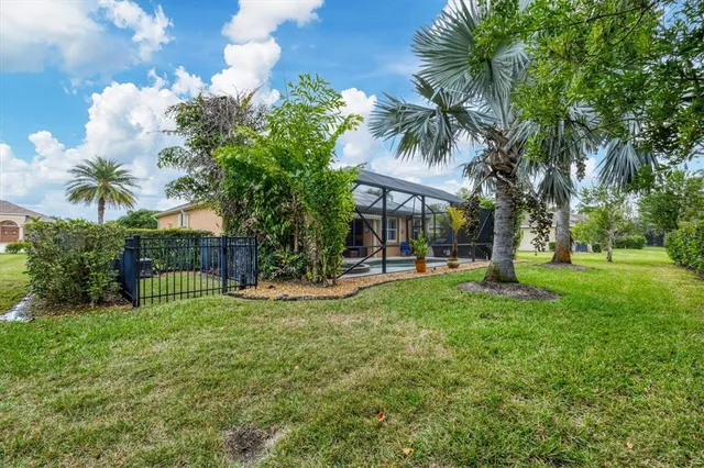a view of a house with a yard and palm trees