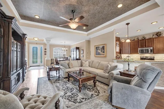 a living room with furniture kitchen and a chandelier