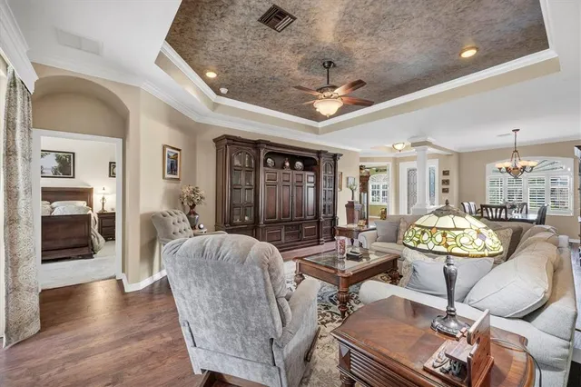 a living room with furniture a chandelier and a wooden floor