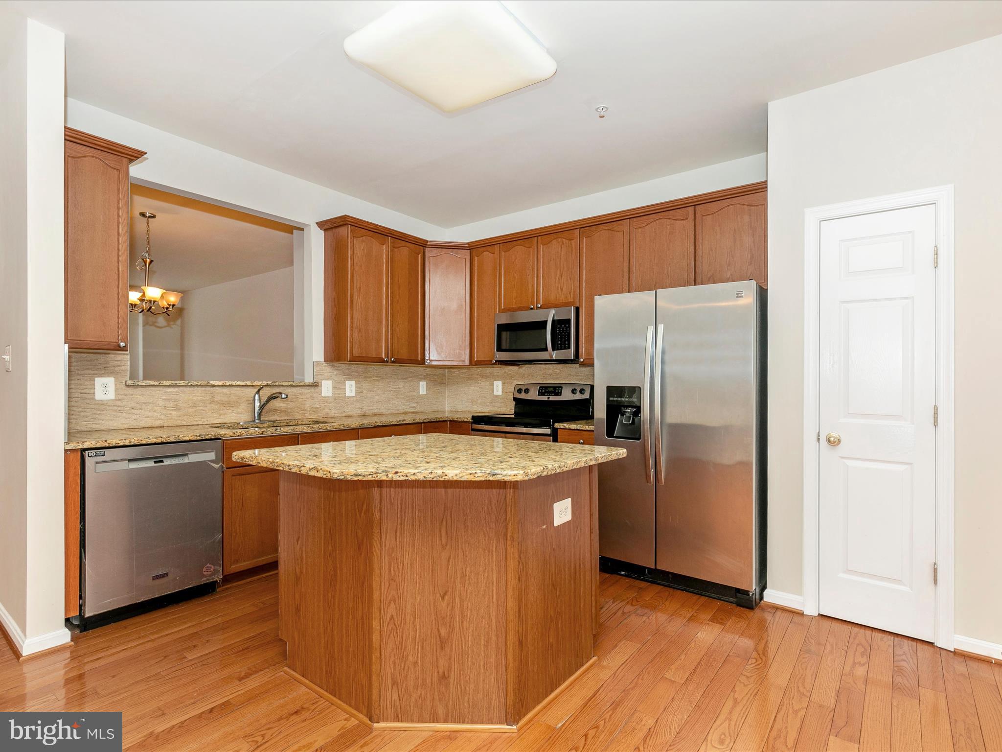 2534 Emerson Drive Frederick, MD 21702 - Photo 24 of 55 a kitchen with stainless steel appliances granite countertop a refrigerator a sink dishwasher a stove with wooden floor and cabinets