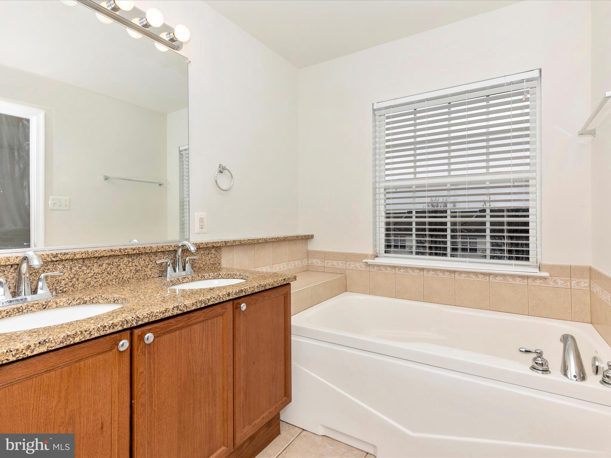 2534 Emerson Drive Frederick, MD 21702 - Photo 34 of 55 a bathroom with a granite countertop sink and a bathtub