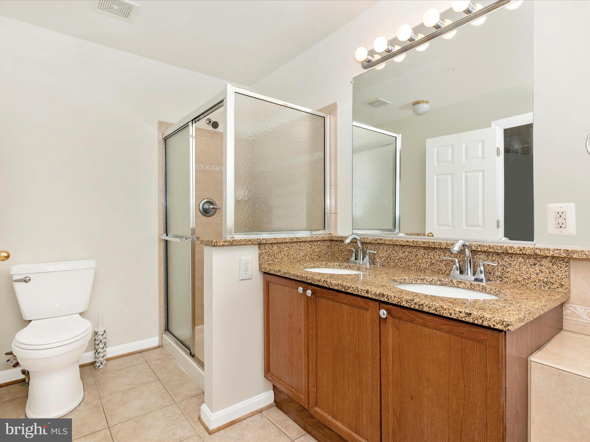 2534 Emerson Drive Frederick, MD 21702 - Photo 35 of 55 a bathroom with a granite countertop sink a toilet and a mirror