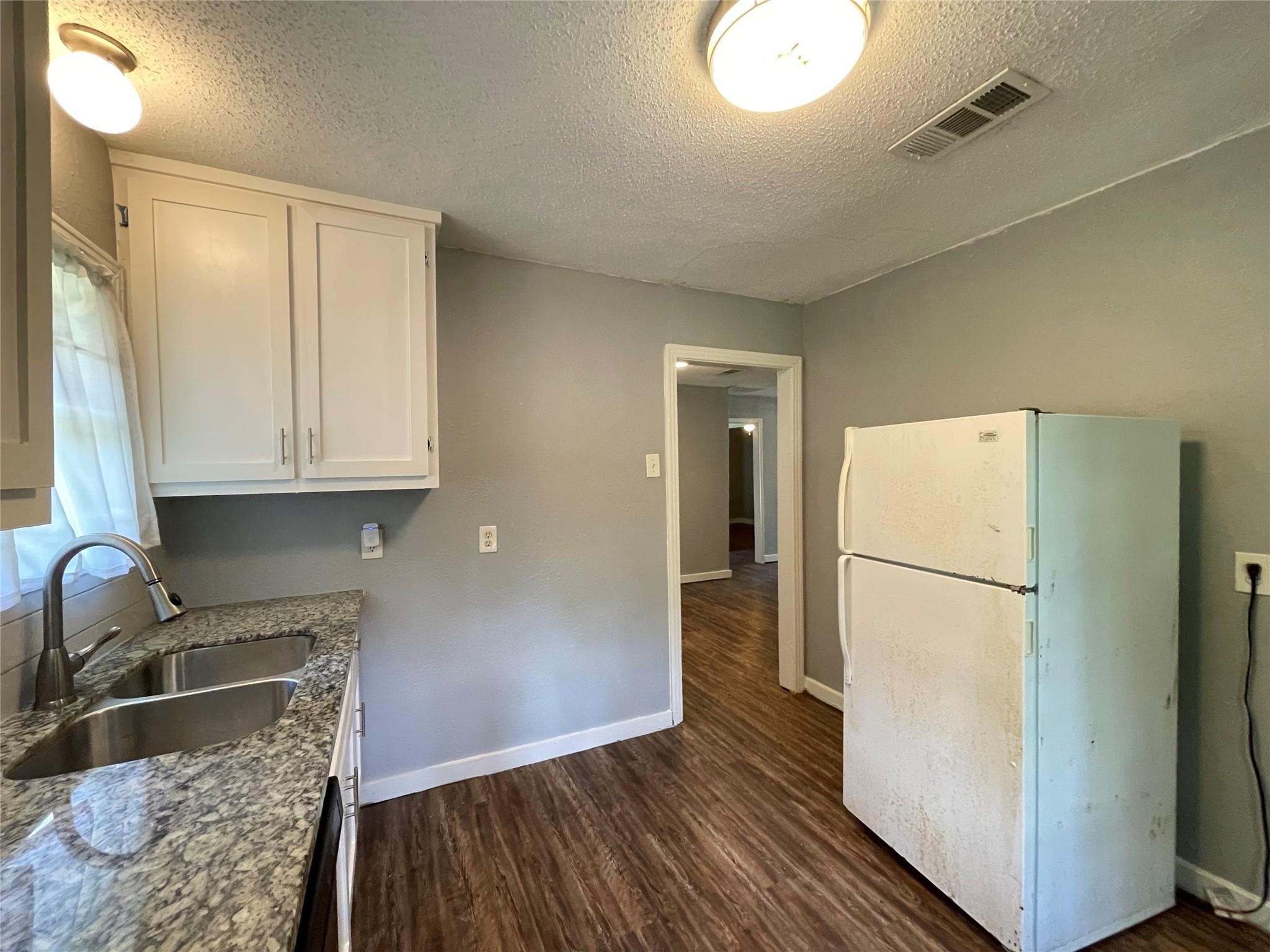 5213 Anzio Road Houston, TX 77033 - Photo 9 of 20 a kitchen with a refrigerator sink and cabinets