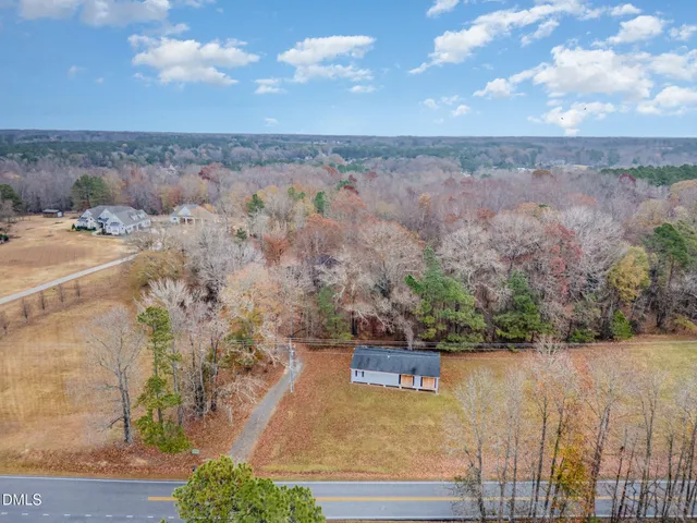 an aerial view of a house with a yard and lake view