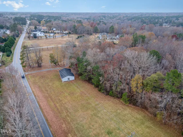 a view of a house with a yard and covered with trees