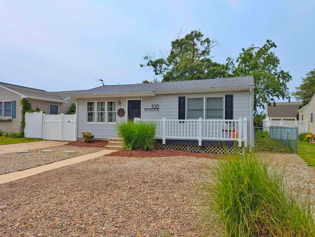 a view of a house with a yard and potted plants