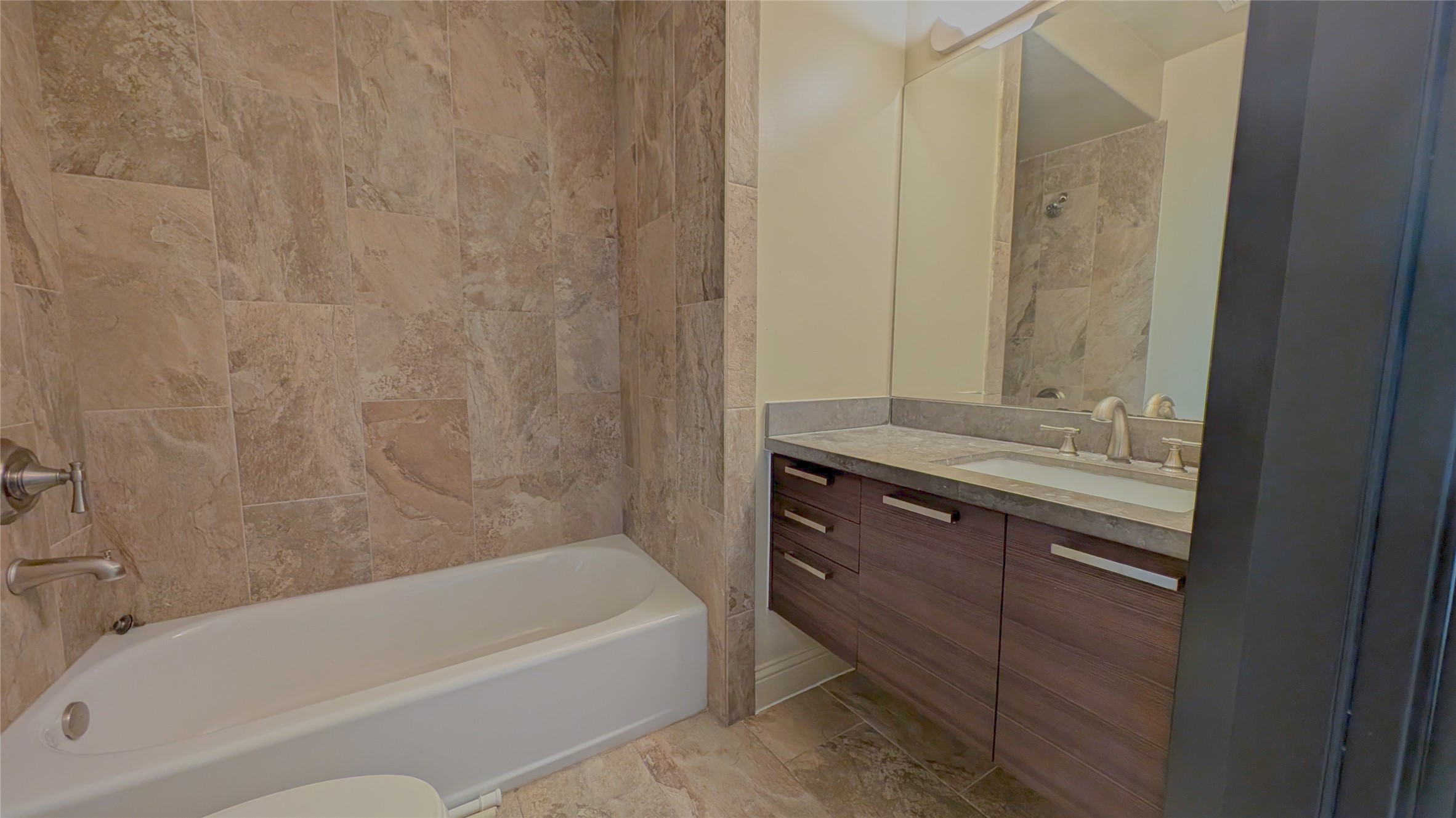 1844 Colquitt Street Houston, TX 77098 - Photo 26 of 40 a bathroom with a granite countertop sink a toilet and bathtub