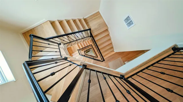 an empty room with wooden floor chandelier fan and windows