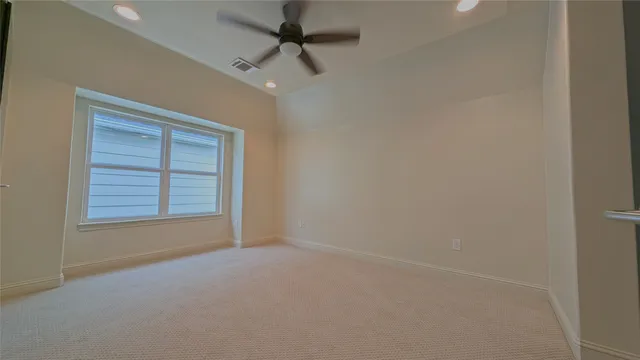 an empty room with a ceiling fan and a window