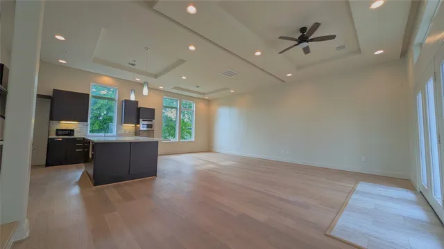 a view of a living room a refrigerator and a wooden floor
