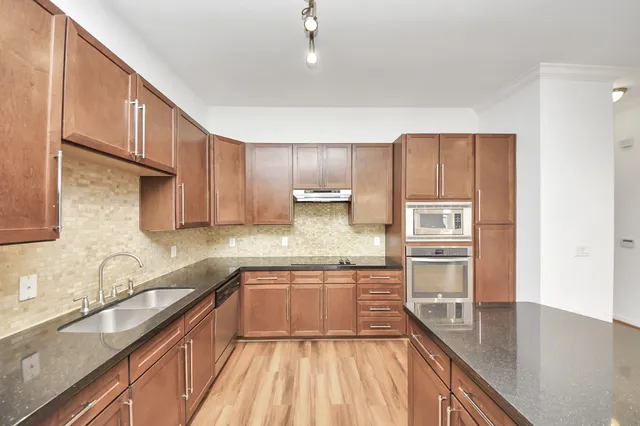 a kitchen with kitchen island granite countertop a sink stove and cabinets