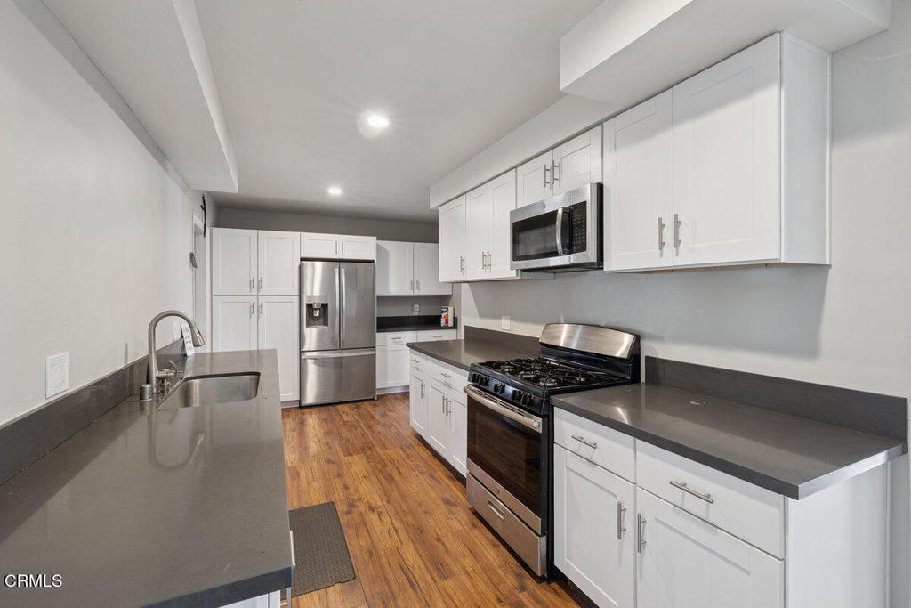 1841 South F Street Oxnard, CA 93033 - Photo 7 of 27 a kitchen with stainless steel appliances a stove a sink a microwave and cabinets