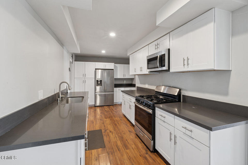 1841 South F Street Oxnard, CA 93033 - Photo 9 of 27 a kitchen with stainless steel appliances granite countertop a stove microwave and sink