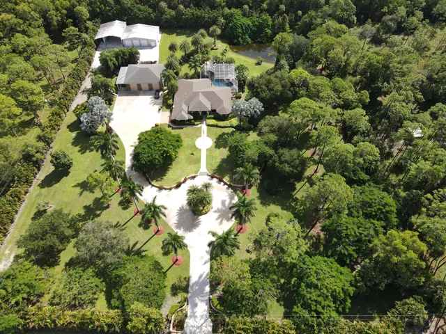 an aerial view of a house with a yard and lake view
