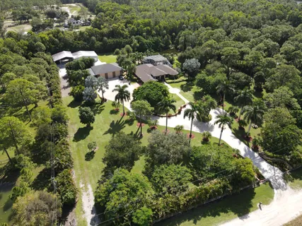 an aerial view of a house with a yard and lake view