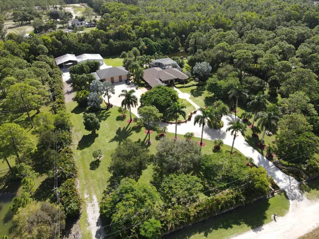an aerial view of a house with a yard and lake view