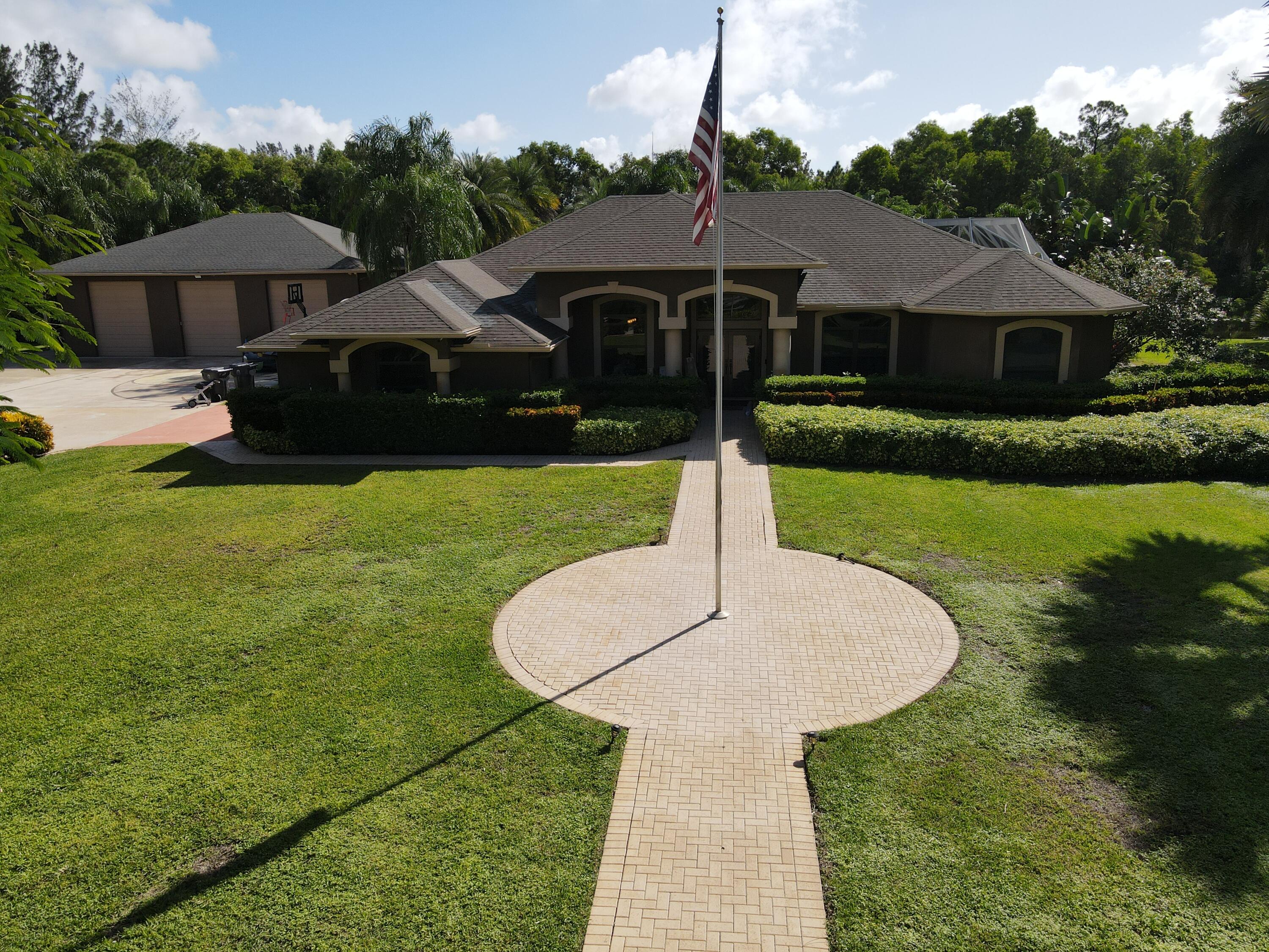 3516 185th Trail Loxahatchee, FL 33470 - Photo 7 of 56 a front view of a house with garden