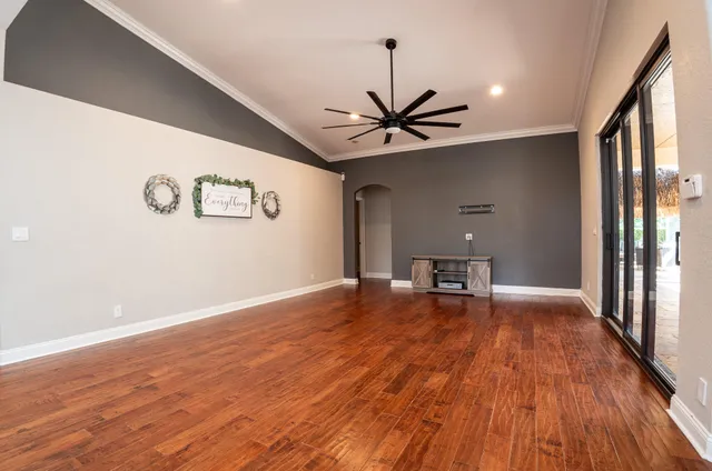 a view of an empty room with window and wooden floor