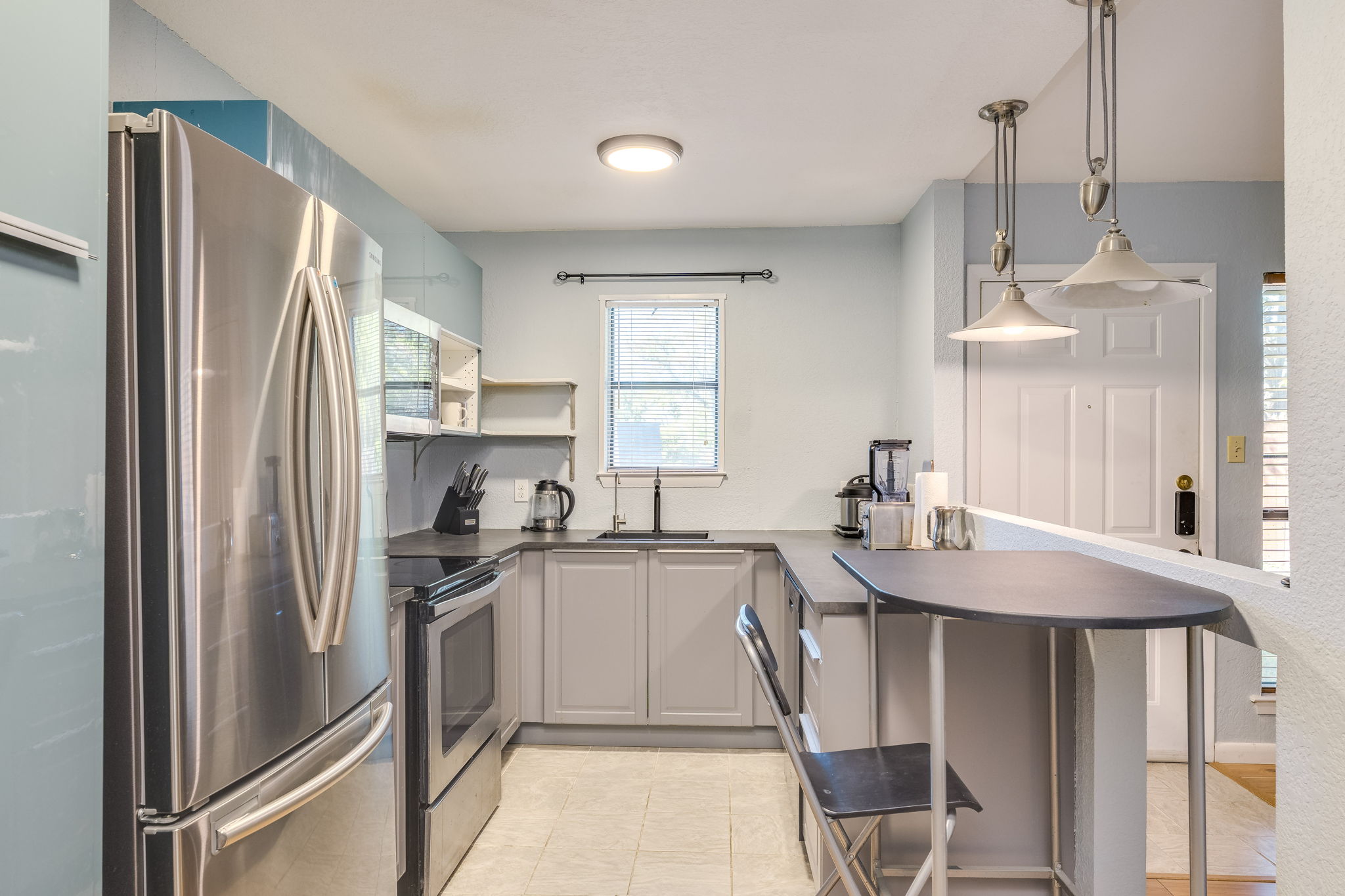 4307 South 1st Street, Unit 101 Austin, TX 78745 - Photo 12 of 33 a kitchen with stainless steel appliances granite countertop a sink refrigerator and cabinets