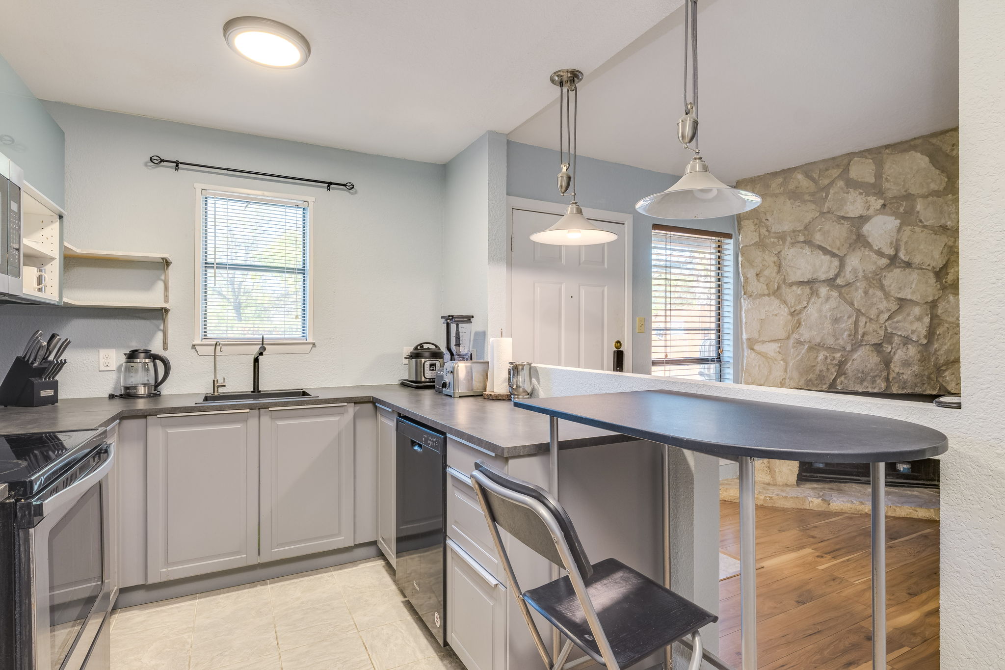 4307 South 1st Street, Unit 101 Austin, TX 78745 - Photo 13 of 33 a kitchen with a sink a stove a window and cabinets
