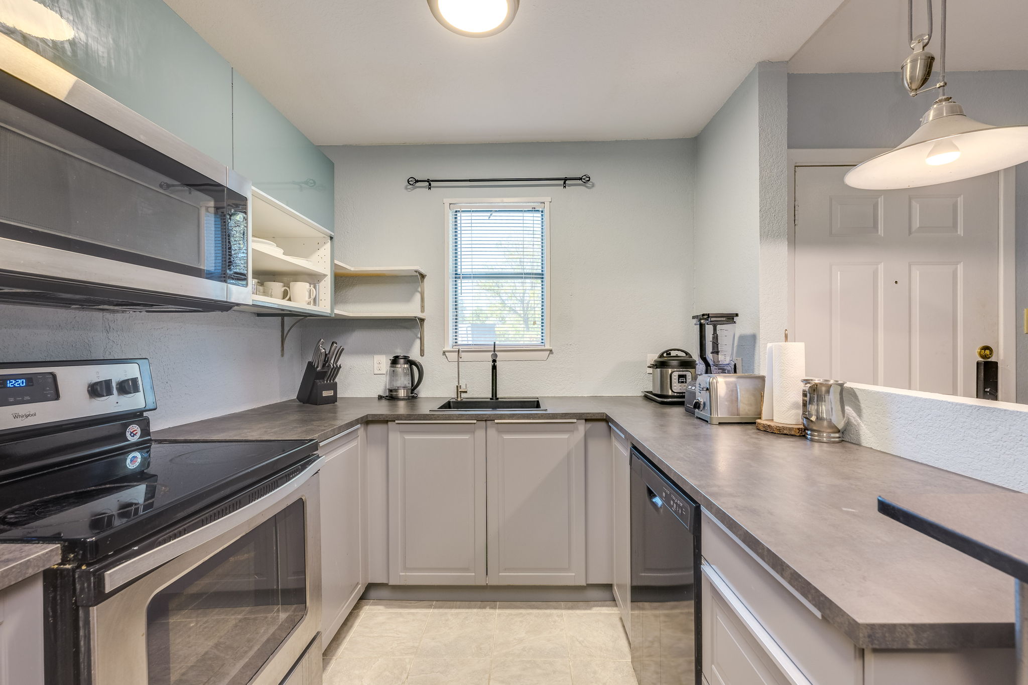 4307 South 1st Street, Unit 101 Austin, TX 78745 - Photo 14 of 33 a kitchen with a sink a stove and cabinets