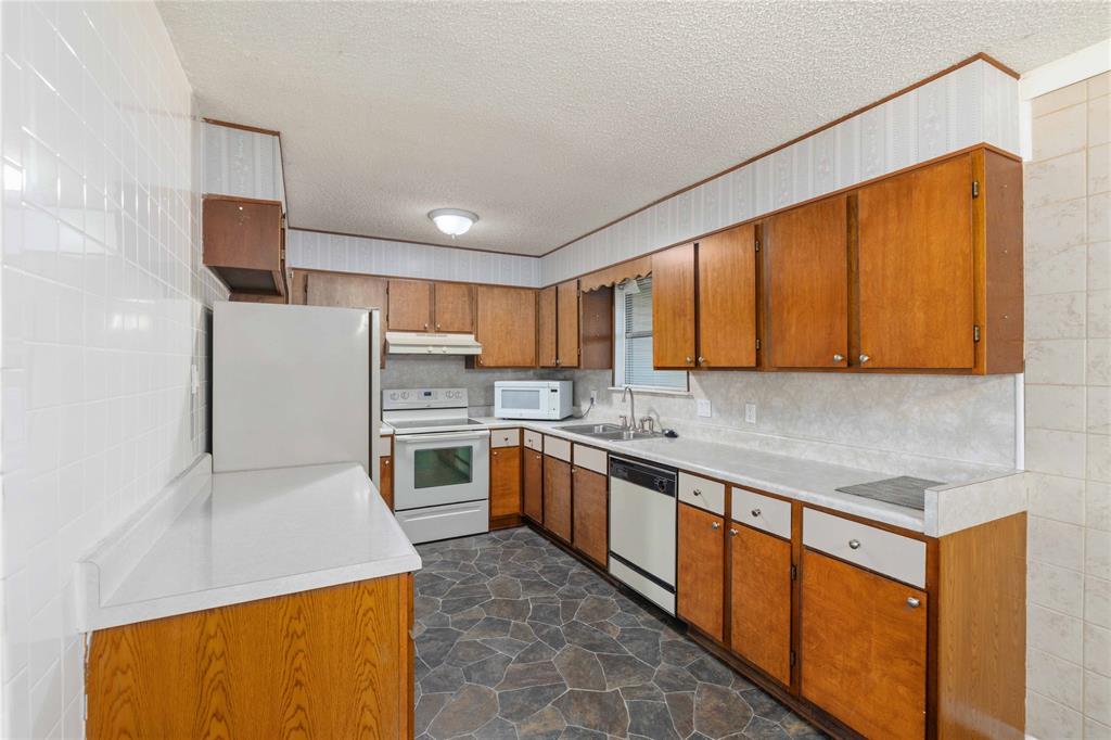 100 County Road 319 Early, TX 76802 - Photo 11 of 39 a kitchen with stainless steel appliances granite countertop a stove a sink dishwasher and a refrigerator