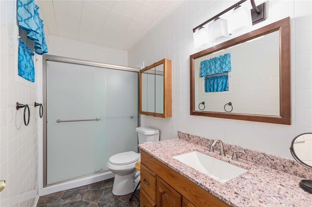 100 County Road 319 Early, TX 76802 - Photo 18 of 39 a bathroom with a granite countertop sink toilet and shower