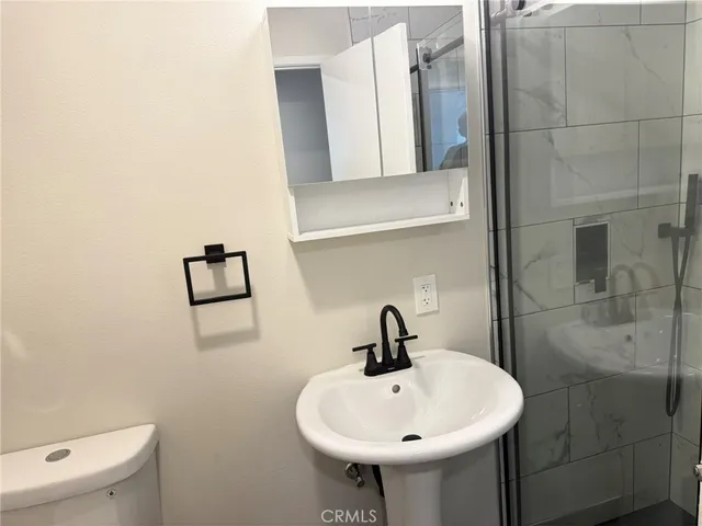 a bathroom with a sink a toilet and mirror