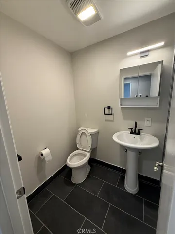 a bathroom with a sink toilet and a mirror