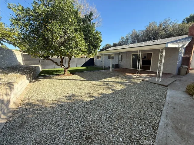 a view of a house with a yard and large tree