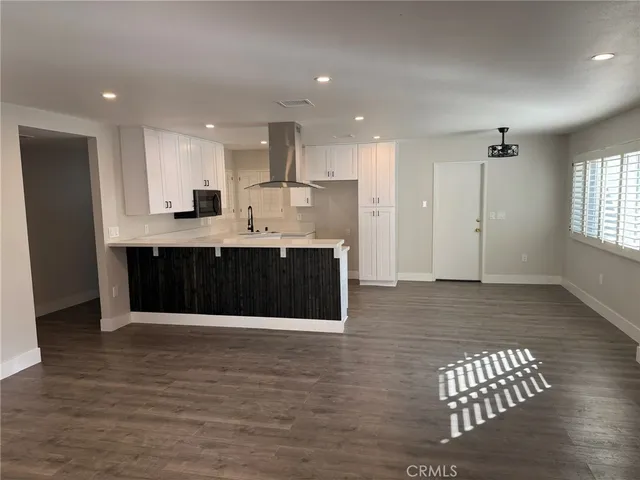 a kitchen with kitchen island granite countertop a sink and refrigerator