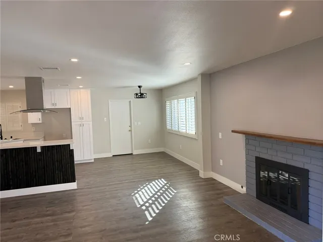 a view of a kitchen with a sink a fireplace and window