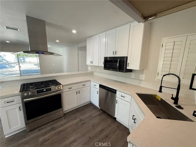 a kitchen with a sink stove top oven and refrigerator